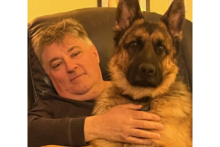 Bill with his large German Shepard on his lap