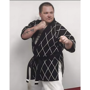 Bob in martial arts robes and belt holding his fists up at the ready