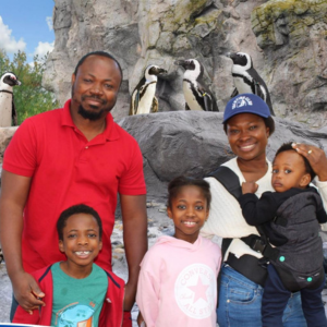 Daniel with his family at the zoo, penguins in the background